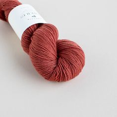 a skein of red yarn sitting on top of a white surface