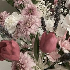 a vase filled with lots of pink and white flowers