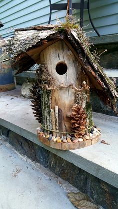 a bird house made out of logs and pine cones