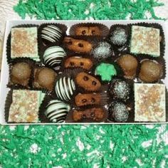 a box filled with assorted chocolates on top of a green carpeted floor