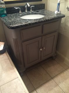 a bathroom with a sink, mirror and toiletries on the counter top in it