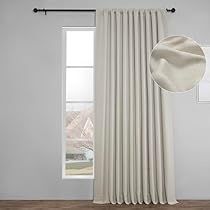 a white curtain hanging on the side of a window in front of a wooden floor