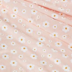 a pink and white flowered fabric with gold polka dots on the bottom half of it