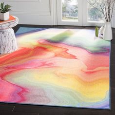 a multicolored area rug in front of a white door with potted plants