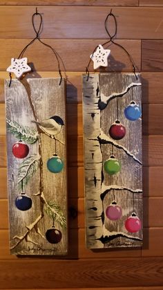 two wooden wall hangings decorated with ornaments and snowflakes on wood planks