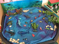 an ocean scene made out of plastic with rocks and sea animals on the bottom half