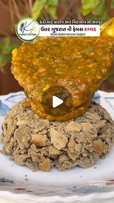 a white plate topped with food on top of a pile of dirt next to a potted plant