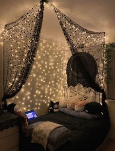 a bedroom decorated with fairy lights and string lights on the walls, along with a bed that has a netted canopy over it