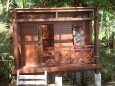 a wooden house sitting on top of a lush green forest