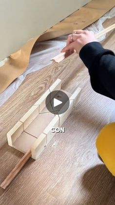 a person is working on some kind of project with wood and plastic construction materials in the background