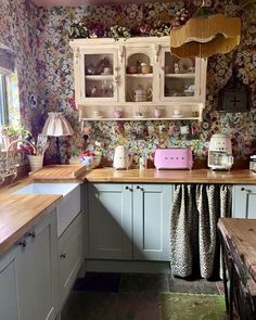 a kitchen with floral wallpaper and wooden counter tops