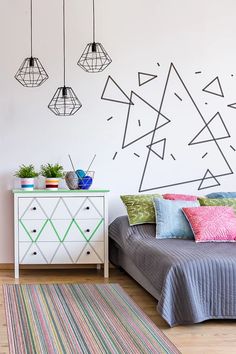 a bedroom with a bed, dresser and hanging lights