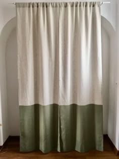 a white and green curtain hanging on the side of a wall