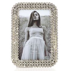 a woman wearing a white dress is shown in a frame with pearls on the edges