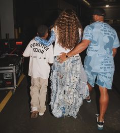 two men and a woman walking towards an airport