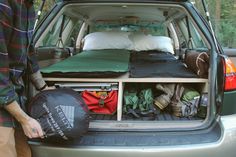 the back end of a car with an open trunk and sleeping bag in it's cargo compartment