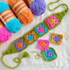 crocheted items are displayed on a white tablecloth, including balls of yarn