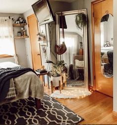 a bedroom with a large mirror on the wall next to a bed and rugs