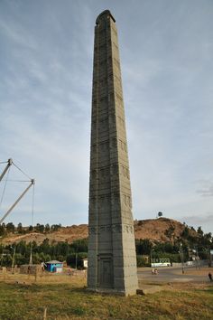 an obelisk in the middle of a grassy field