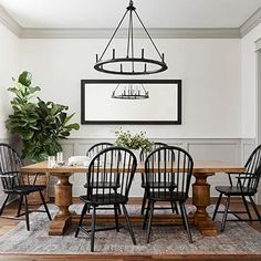 a dining room table with four chairs and a potted plant