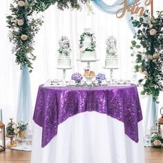 the table is covered with pink sequins and white flowers, along with two tiered cake stands