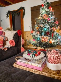 a living room with a christmas tree in the corner and decorations on the coffee table