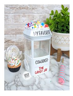 a cupcake is sitting next to a candy jar