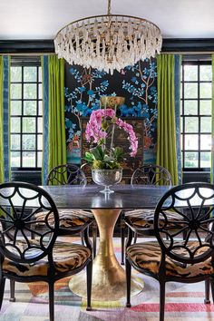 a dining room table with four chairs and a chandelier hanging from the ceiling