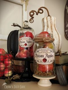 two jars filled with apples sitting on top of a table