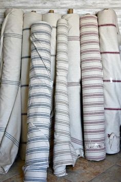 towels lined up on the floor in front of a wall with white and blue stripes