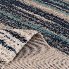 an area rug with blue, beige and green stripes on it's edges is shown in close up