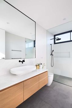 a bathroom with two sinks and a large mirror over the bathtub, along with a walk in shower