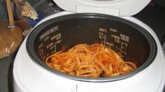 a bowl filled with pasta sitting on top of a counter next to a blender