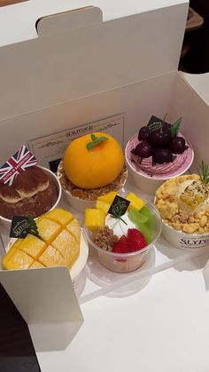 a box filled with lots of different types of cakes and desserts next to each other