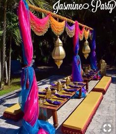 a long table with purple and blue cloths on it is set up for a party