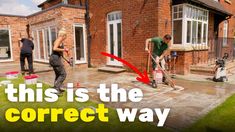 two men are cleaning the yard with mop's in front of a house