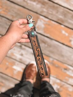 the person is holding an old pair of scissors in their hand and they are standing on a wooden floor