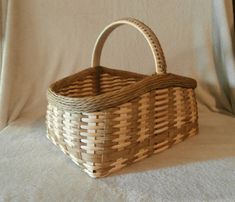 a wicker basket sitting on top of a white sheet