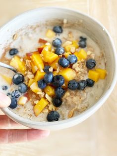 a bowl of oatmeal with blueberries and peaches