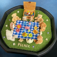 there is a picnic with teddy bears on the grass in front of it and a picnic table surrounded by stuffed animals