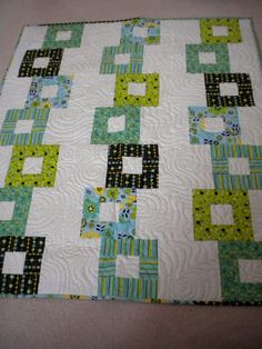 a quilted table topper with green and blue squares on it's sides