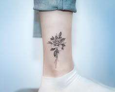 a woman's foot with a rose tattoo on the left side of her leg