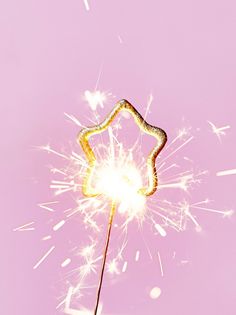 a yellow sparkler on a pink background