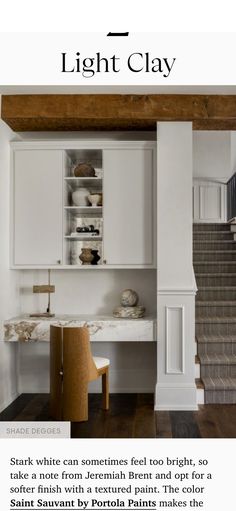 a white kitchen with stairs leading up to it