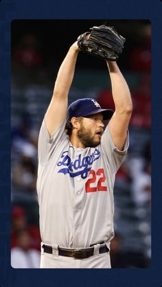 a baseball player is holding his glove up in the air while wearing a hat and uniform