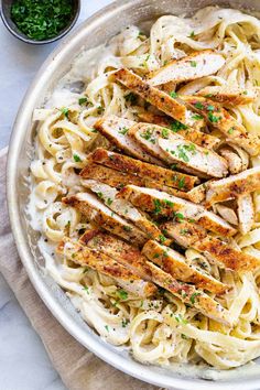 chicken alfredo in a bowl with parsley on the side