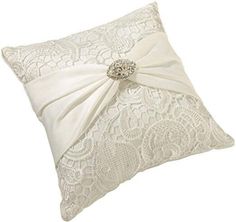 a white pillow with a bow on the side and lace trimmings around it