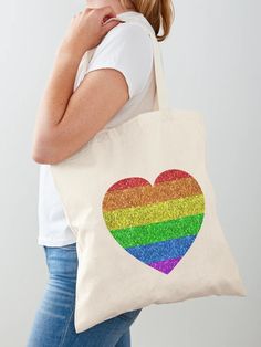 a woman carrying a tote bag with a heart painted on it and rainbow sequins