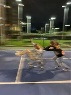 two people on a tennis court with a shopping cart