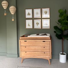 a baby's crib in the corner of a room with pictures on the wall